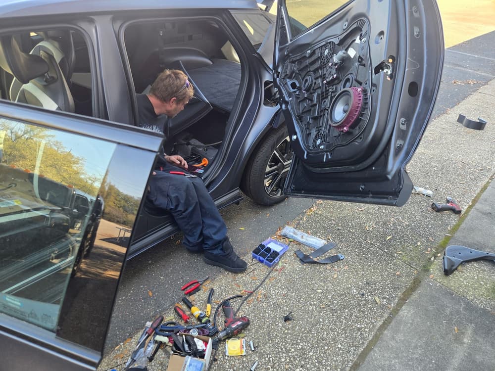 Mobile welder doing an on-site repair beside a vehicle in a parking lot